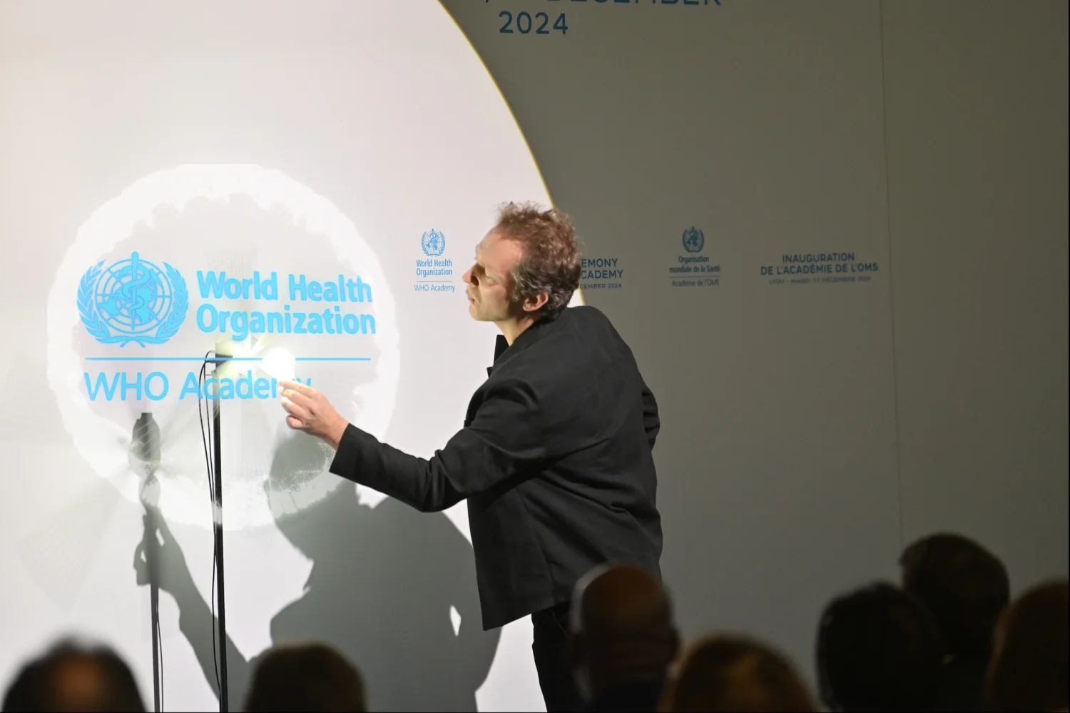 The inauguration of the WHO Academy in Lyon: the magician makes the World Health Organization logo appear in the propeller, in front of the seated audience.
