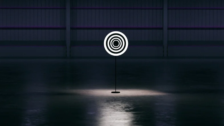 Holo 1 : une hélice unique sur pied projette une cible lumineuse concentrique dans un hall sombre.