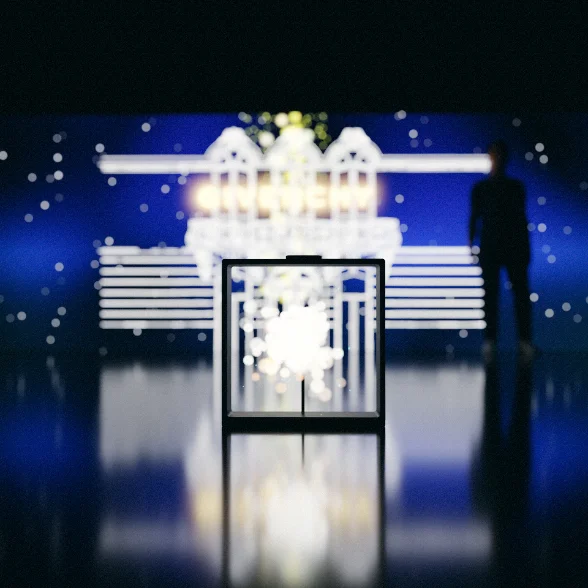 Installation sur scène : un hologramme dans un cadre vertical devant un décor LED bleu et blanc.